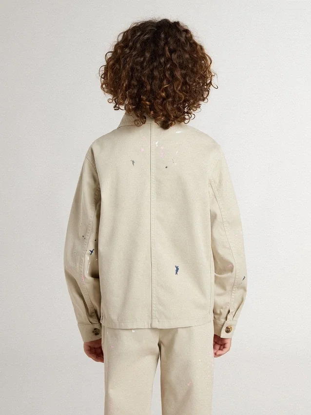Beige barnjacka med flerfärgade stänk