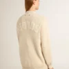 Beige damkofta med texten ”Golden” på ryggen