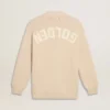 Beige damkofta med texten ”Golden” på ryggen