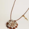 Blomcharm i beige och champagnefärgat läder