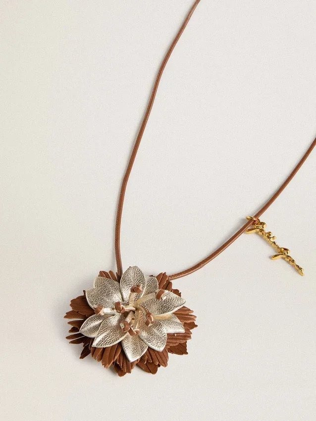 Blomcharm i beige och champagnefärgat läder