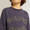 Blåviolett sweatshirt med text från golden goose på framsidan