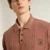 Brickfärgad polotröja för herr med broderad logotyp.