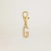 G-charm i guldfärgad mässing med kristaller