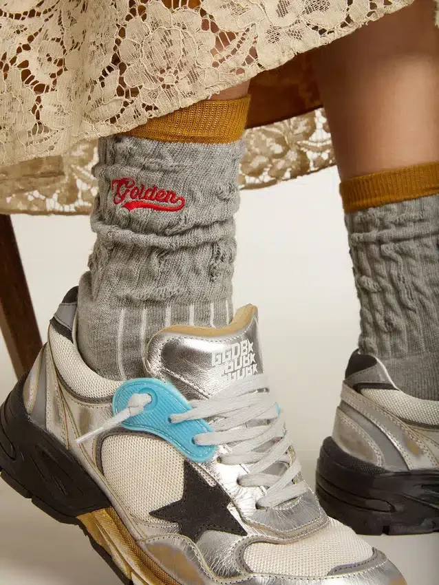 Grå ribbade strumpor med orange detaljer och rött logo