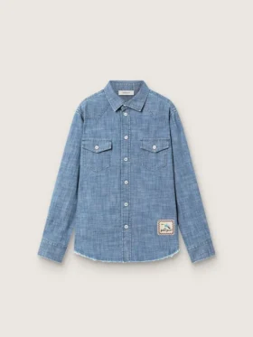 Journey unisex-skjorta i ljusblå bomullschambray med fransad nederkant och broderad patch
