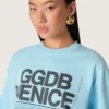Kort T-shirt för damer i ljusblå bomullsjersey med grafiskt tryck