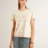 Krämfärgad T-shirt för dam med blekta röda detaljer