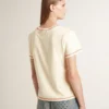 Krämfärgad T-shirt för dam med blekta röda detaljer