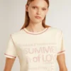 Krämfärgad T-shirt för dam med blekta röda detaljer