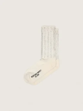 Krämfärgade strumpor med slitna detaljer och strass
