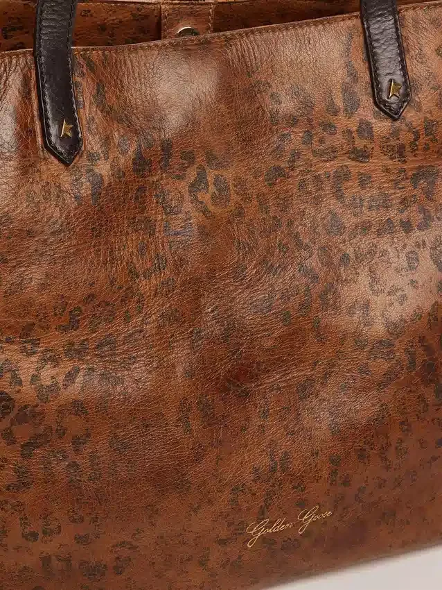 Pasadena-väska i hamrat läder med leopardmönster och kontrasterande svarta handtag