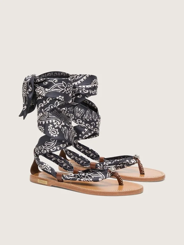 Platta sandaler med mörkblått paisleymönster och smyckesdetaljer