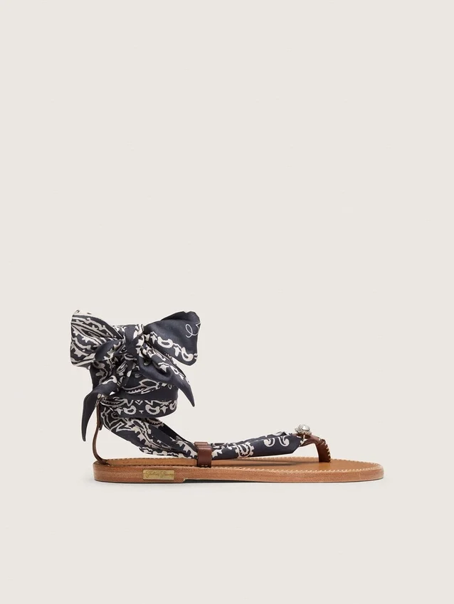 Platta sandaler med mörkblått paisleymönster och smyckesdetaljer