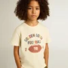 Pojk-T-shirt i slitet vitt med flerfärgad text