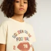Pojk-T-shirt i slitet vitt med flerfärgad text
