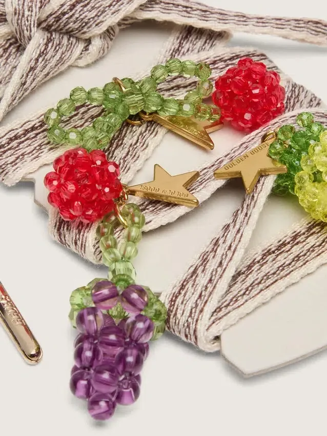 Skinn krämfärgade och duvgrå randiga broderade skosnören med tre fruktformade pärlberlocker