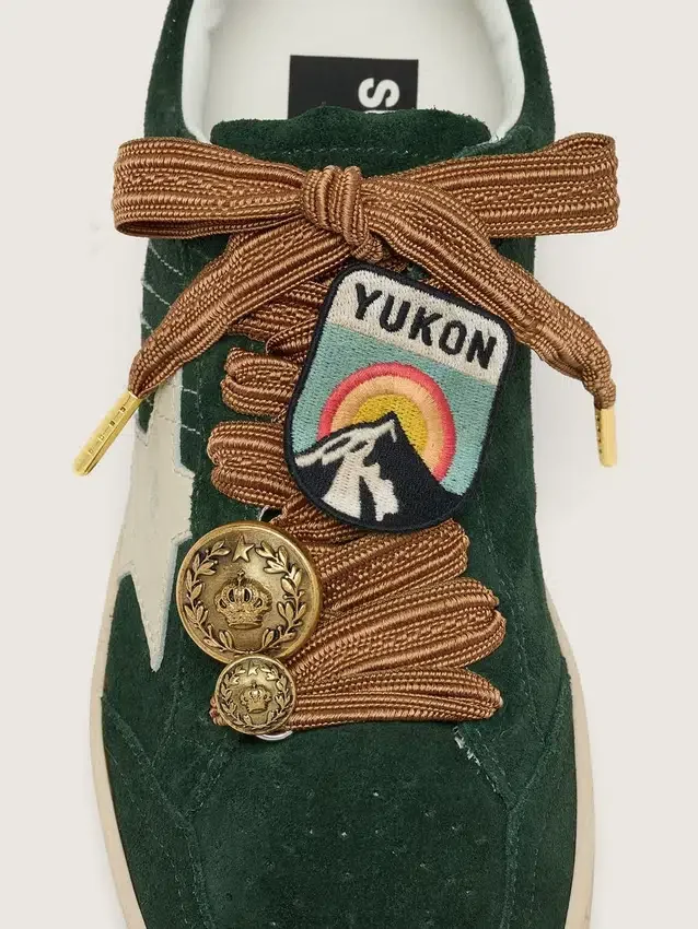 Skinn med broderade skosnören i vinrött och persika med patch och två berlocker