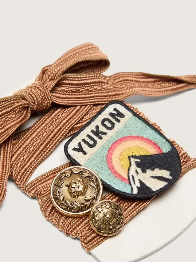 Skinn med broderade skosnören i vinrött och persika med patch och två berlocker