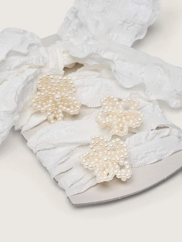 Skinn vita skosnören med blomformade pärlbroderier