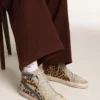 Slide i ponnyskinn med leopardmönster och silverfärgad läderstjärna
