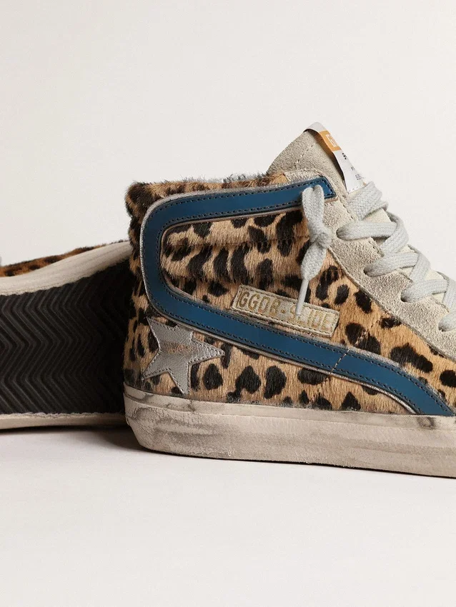 Slide i ponnyskinn med leopardmönster och silverfärgad läderstjärna