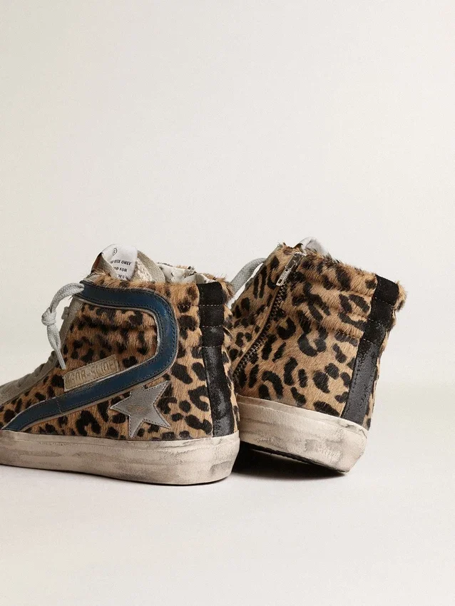 Slide i ponnyskinn med leopardmönster och silverfärgad läderstjärna
