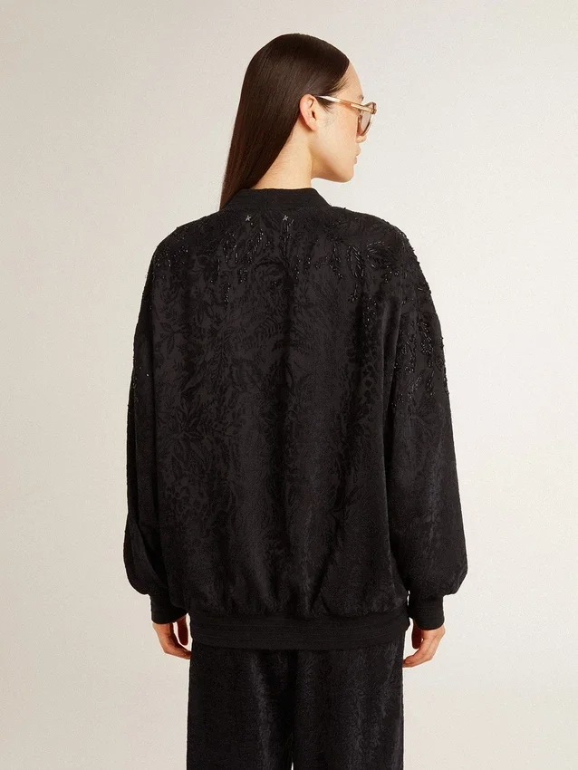 Svart damkofta med ton-i-ton-broderi i toile de jouy-stil