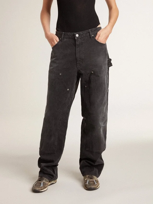 Svarta jeans i bomull med slitna detaljer och lappar framtill för dam