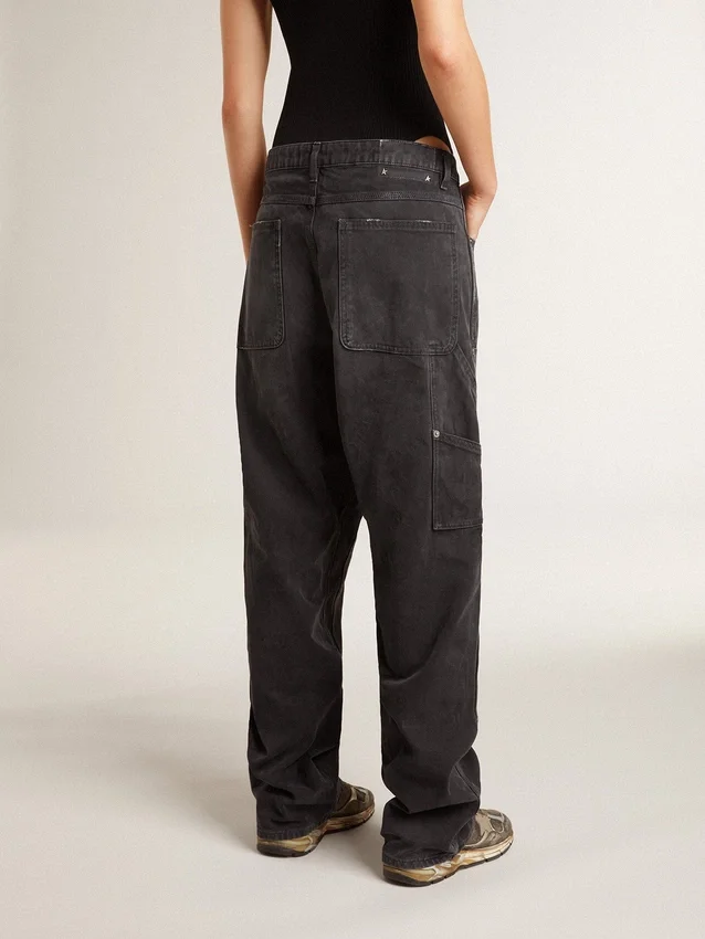 Svarta jeans i bomull med slitna detaljer och lappar framtill för dam