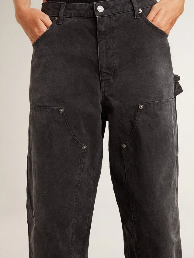 Svarta jeans i bomull med slitna detaljer och lappar framtill för dam
