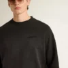 Unisex-sweatshirt i sliten svart bomull med broderad logotyp