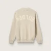 Unisex-tröja med rund hals i beige bomull med patch på framsidan och logotyp på baksidan
