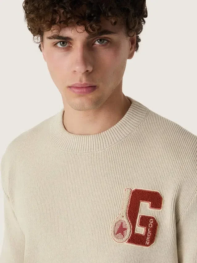 Unisex-tröja med rund hals i beige bomull med patch på framsidan och logotyp på baksidan